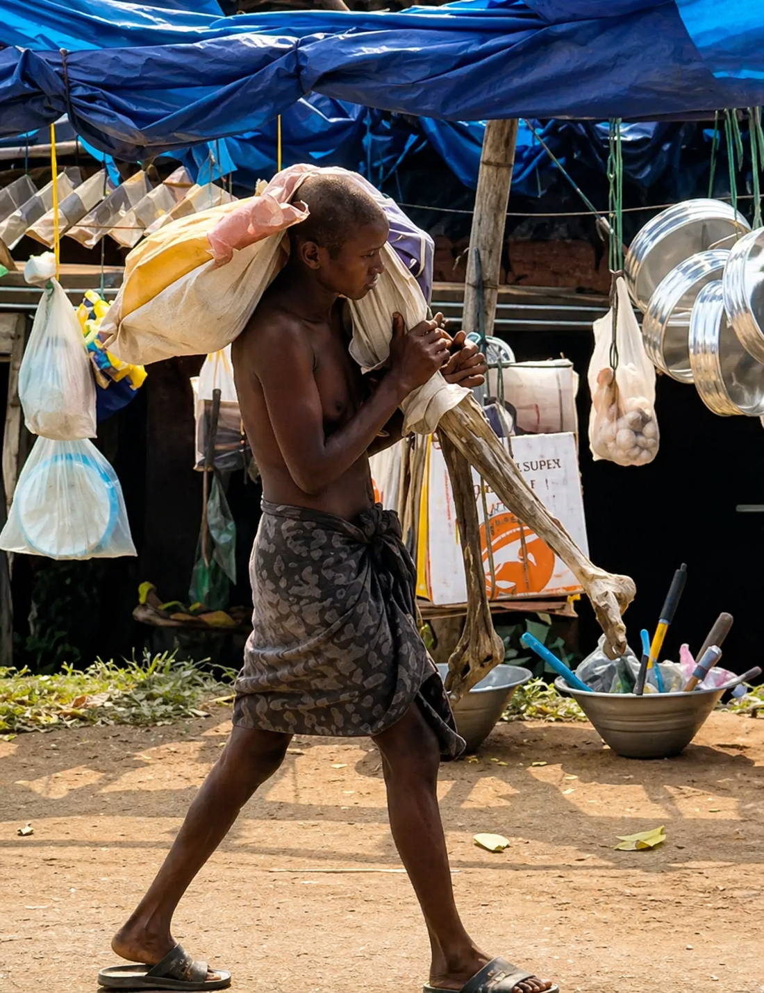 Hombre camina cargando restos humanos envueltos en tela en un mercado de India.