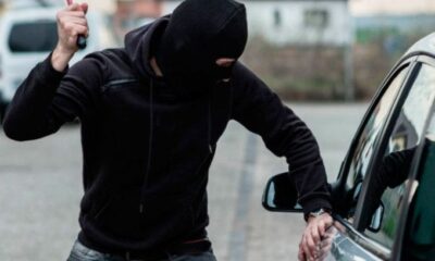 Persona intentando forzar la puerta de un automóvil, representando riesgos de inseguridad en vía pública