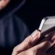 Persona utilizando un teléfono móvil en contexto de redes sociales y ciberacoso