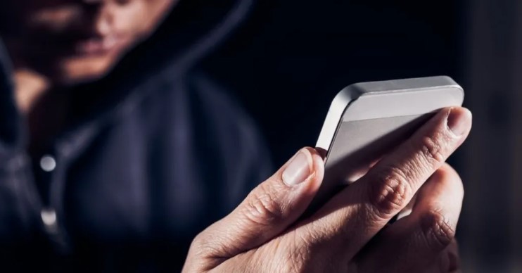 Persona utilizando un teléfono móvil en contexto de redes sociales y ciberacoso