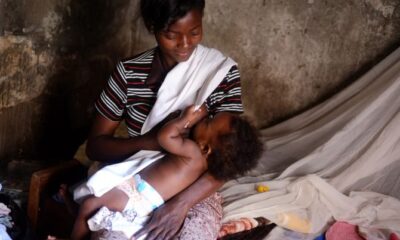 Madre cargando a su bebé durante una campaña relacionada con salud materna y prevención del VIH en América Latina.