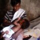 Madre cargando a su bebé durante una campaña relacionada con salud materna y prevención del VIH en América Latina.