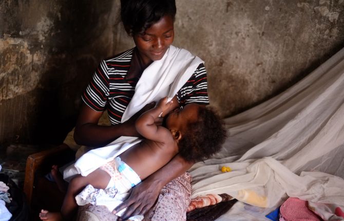 Madre cargando a su bebé durante una campaña relacionada con salud materna y prevención del VIH en América Latina.