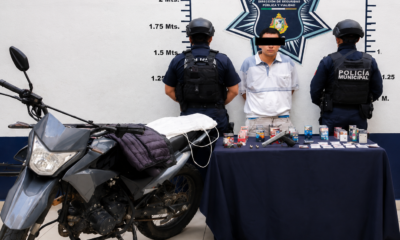 Policías municipales de Atlixco presentan a presunto asaltante detenido tras robo a tienda OXXO junto a objetos asegurados durante el operativo.