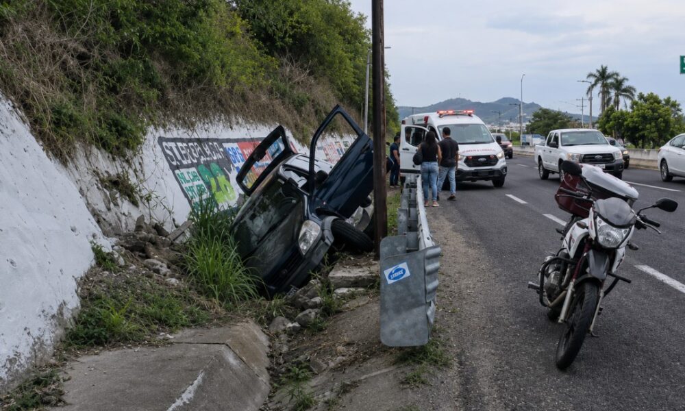 Automóvil accidentado dentro de una zanja en la carretera federal Puebla–Atlixco a la altura del kilómetro 28, mientras paramédicos atienden a una familia lesionada.