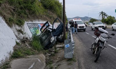Automóvil accidentado dentro de una zanja en la carretera federal Puebla–Atlixco a la altura del kilómetro 28, mientras paramédicos atienden a una familia lesionada.