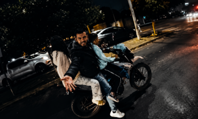 Motocicleta transportando a varios pasajeros sin equipo de protección durante la noche, ejemplo de riesgos de seguridad vial y conducción imprudente en México.