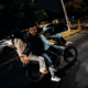 Motocicleta transportando a varios pasajeros sin equipo de protección durante la noche, ejemplo de riesgos de seguridad vial y conducción imprudente en México.