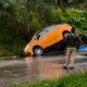 Automóvil color naranja dentro de una cuneta tras derrapar sobre pavimento mojado en la carretera federal Puebla-Atlixco durante temporada de lluvias.