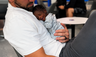 Padre sostiene a un bebé prematuro de muy bajo peso en un área hospitalaria, imagen relacionada con supervivencia neonatal y medicina especializada.
