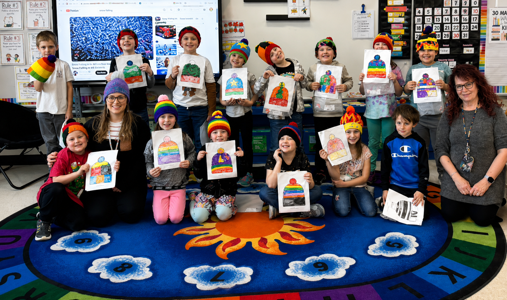 Profesora y alumnos muestran gorros tejidos inspirados en dibujos realizados por los estudiantes dentro de un salón de clases.