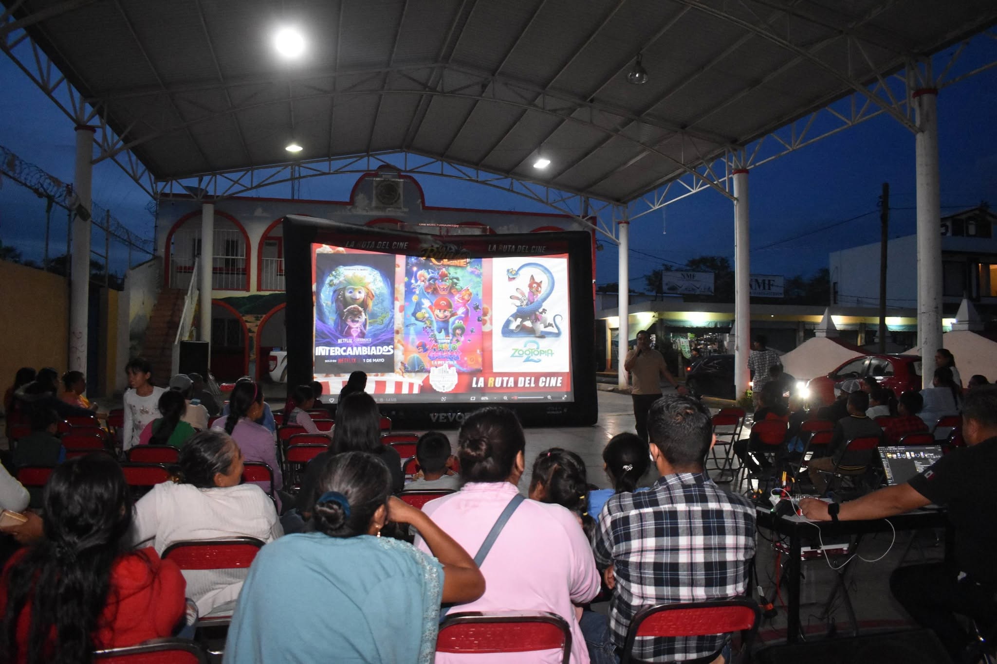 Familias de San Juan Huiluco disfrutan una función gratuita de la Ruta del Cine Móvil organizada por el Ayuntamiento de Huaquechula en pantalla gigante.
