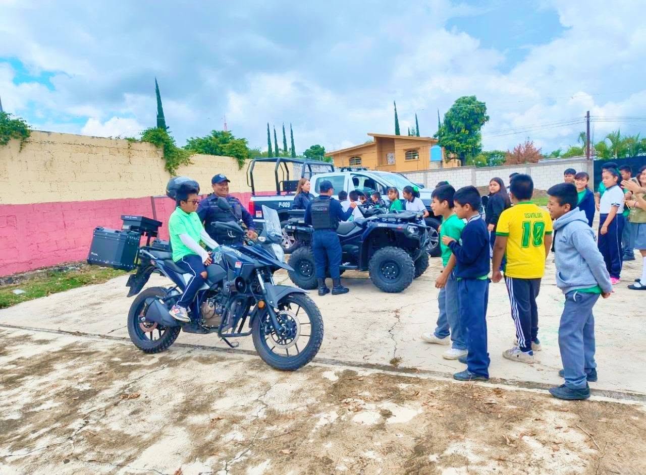 Elementos de Seguridad Pública Municipal muestran vehículos y equipamiento a estudiantes de la Escuela Primaria Miguel Hidalgo en Huaquechula.