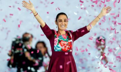 La presidenta de México saluda durante un acto público mientras simpatizantes celebran su cumpleaños número 64.