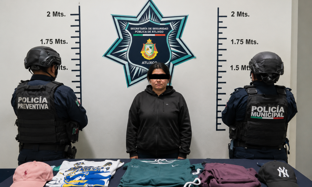 Mujer asegurada por la Policía Municipal de Atlixco tras un reporte de presunto robo en una tienda departamental del Centro; al frente se observan prendas y accesorios recuperados.