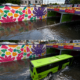 Paso a desnivel inundado en Ciudad de México con autobús circulando entre agua acumulada frente a mural urbano con ajolotes y colores vibrantes.