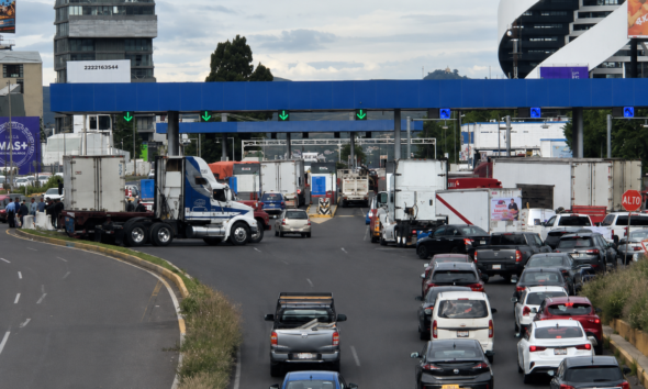 Bloqueo de transportistas de AMOTAC en la caseta de la autopista Puebla–Atlixco, generando congestionamiento vehicular en ambos sentidos.