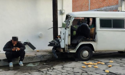 Camioneta tipo combi blanca impactada contra un poste de telefonía en la colonia Santa Rosa Chapulapa, en Atlixco, tras un accidente vial registrado la mañana del 8 de julio de 2026.