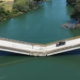 Puente con aparente colapso estructural por el que continúa circulando un vehículo.