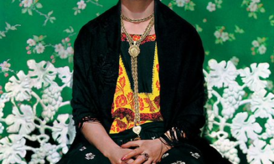 Retrato de Frida Kahlo con flores en la cabeza y vestimenta tradicional mexicana.