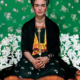Retrato de Frida Kahlo con flores en la cabeza y vestimenta tradicional mexicana.