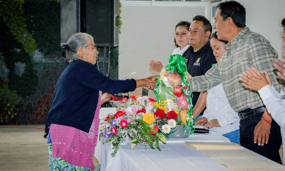 Adultos mayores de Tochimilco reciben sus visas del programa Reuniendo Familias durante una ceremonia encabezada por autoridades municipales.